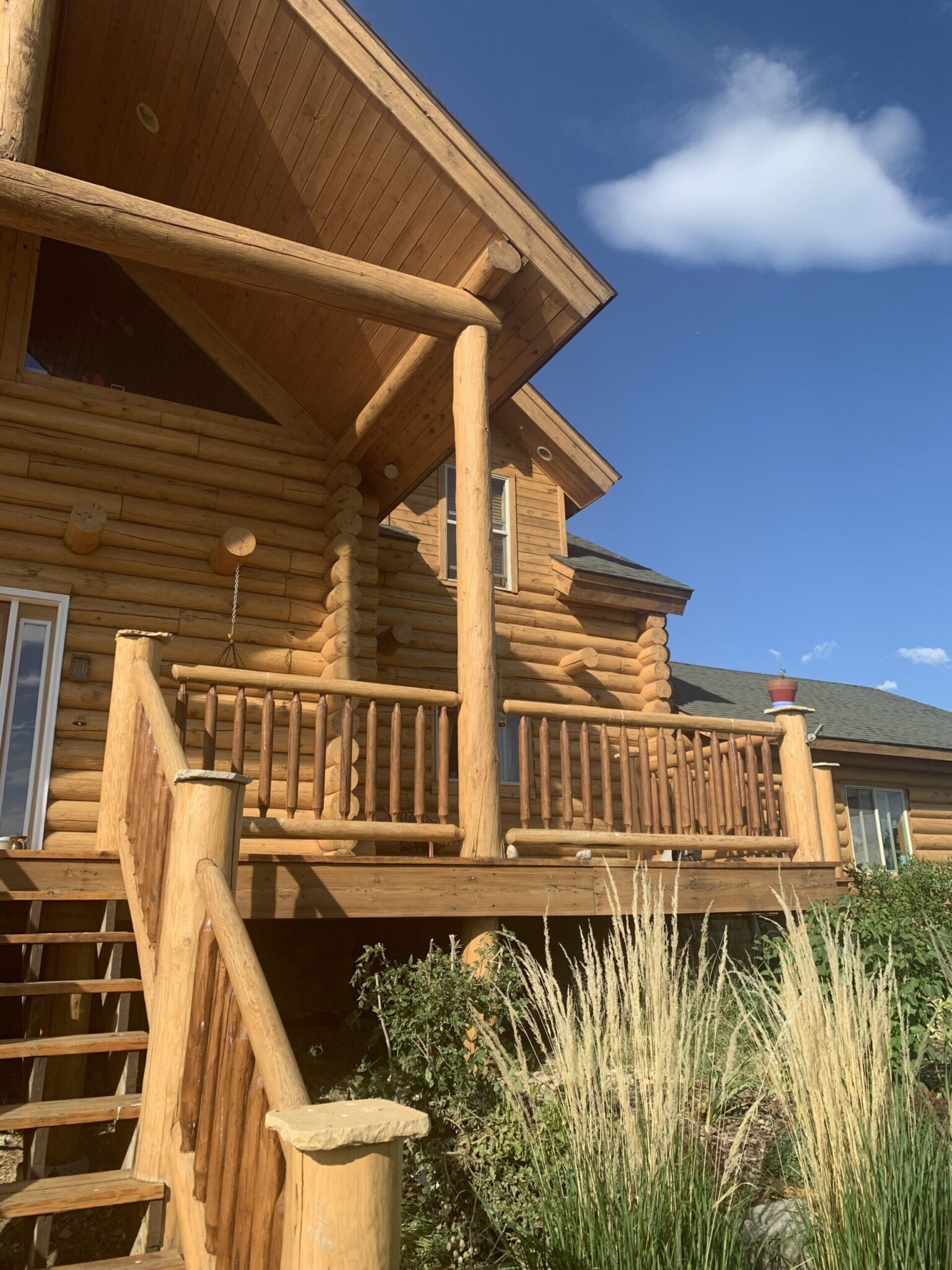 Log home staining in Jackson Hole by Log Care - warm, evenly absorbed stain on log walls, railings and gable ends