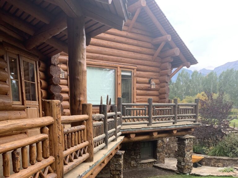 Custom log deck with hand-fit log posts and railing on a Teton County log home