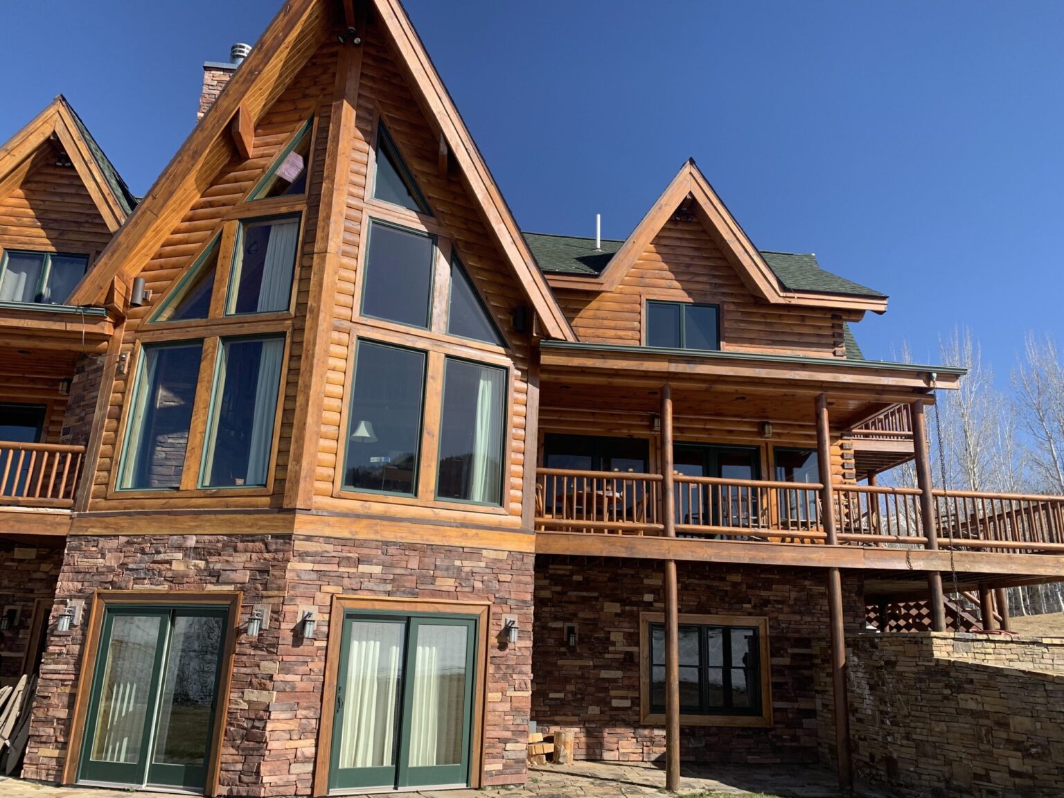 Log home after staining in Teton County - even colour across the full elevation with no lap marks between log courses